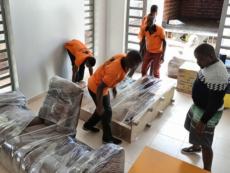 Movers wrapping and preparing furniture